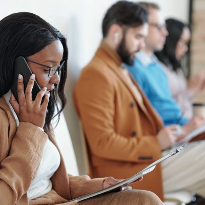 Black woman talking by phone while waiting for job interview browser-based business management software | ABM Strata